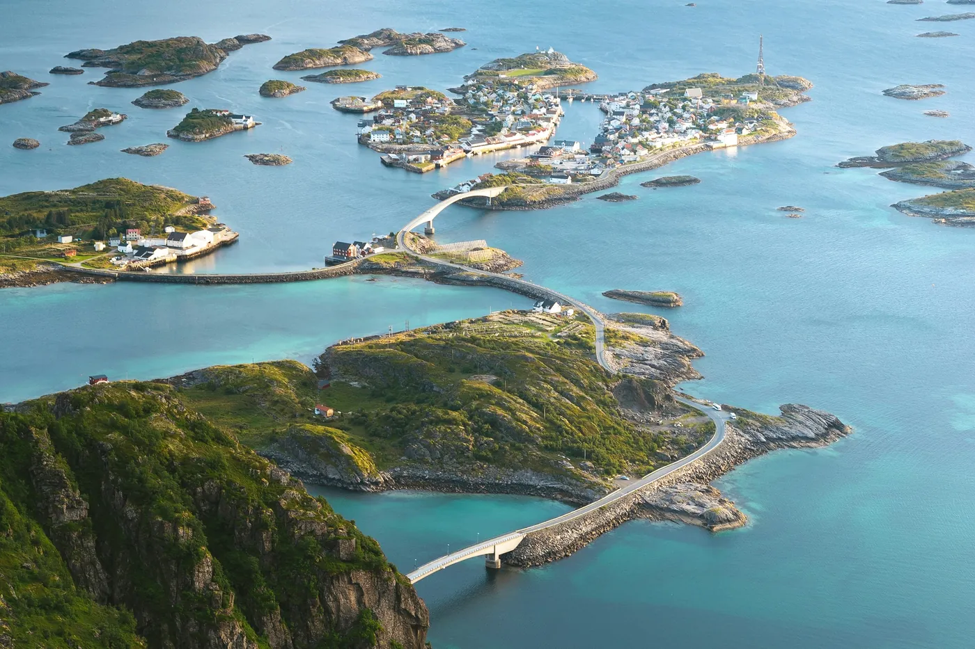 Vista aérea de puentes que unen pequeñas islas y un pueblo pesquero en un mar turquesa